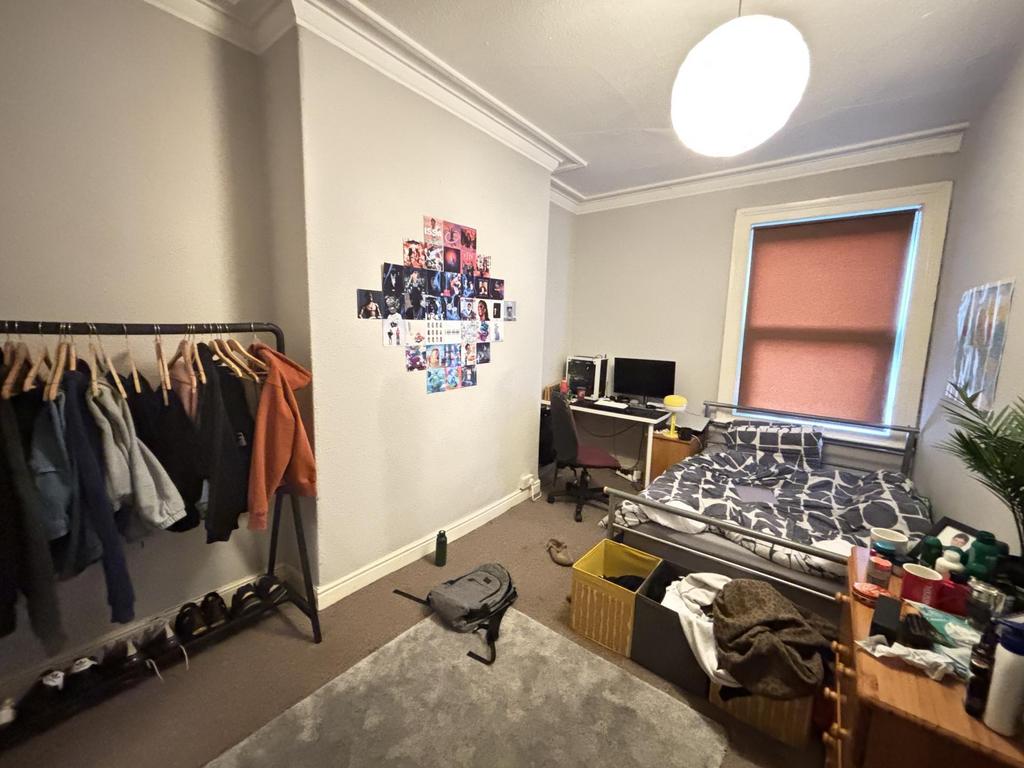 A cozy bedroom featuring a single bed with ampl...