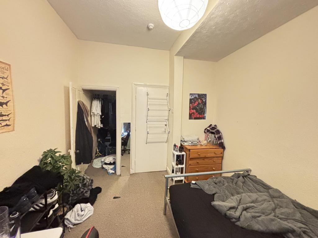 Cozy single bedroom with neutral walls, fitted ...