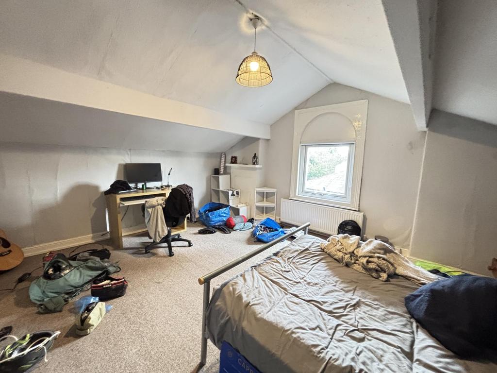 A cozy bedroom with a large window allowing nat...