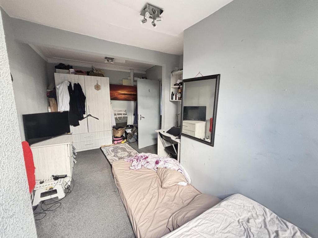 A cozy bedroom with a single bed and minimal cl...