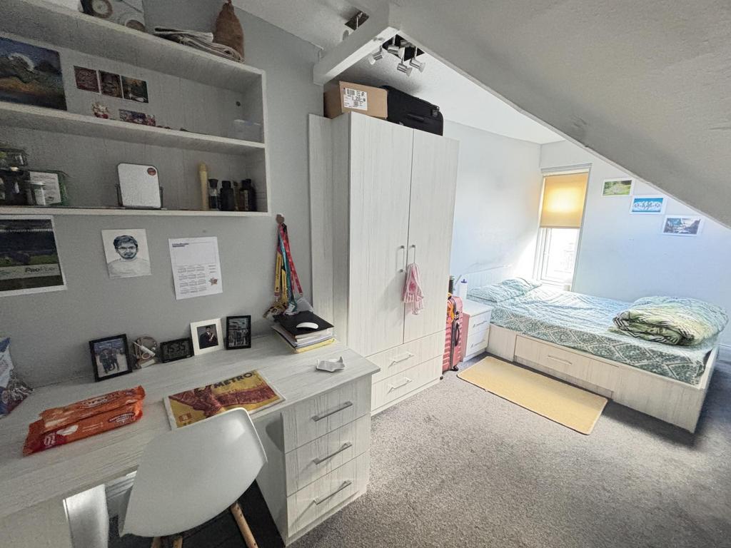 Bright and cozy single bedroom with a neatly ma...