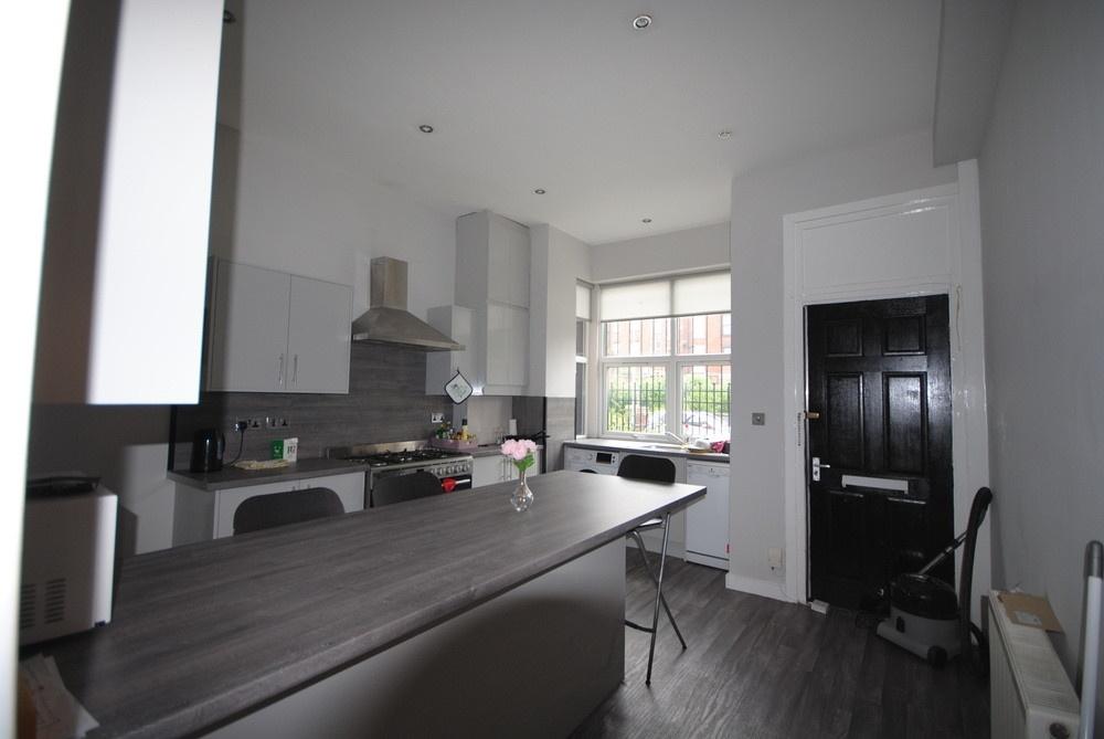 A modern, well-lit kitchen with large windows p...
