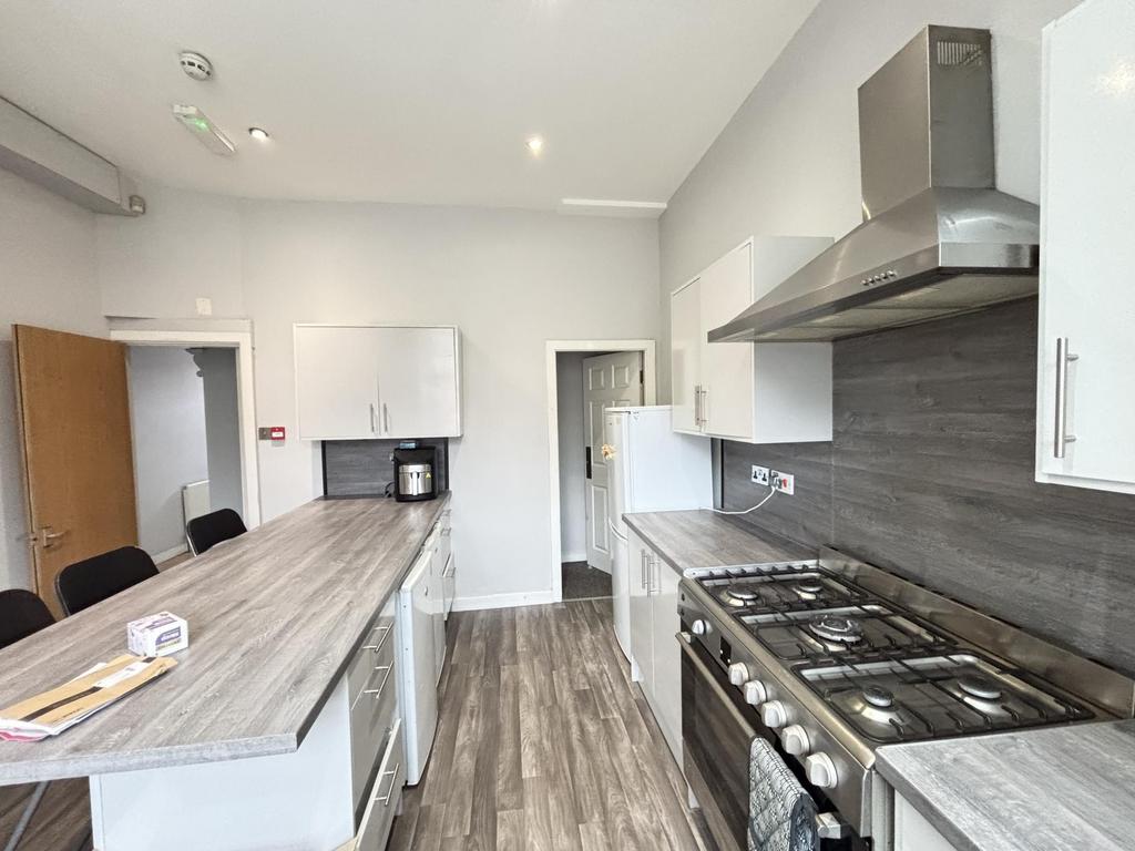 Modern kitchen with sleek white cabinets, a spa...