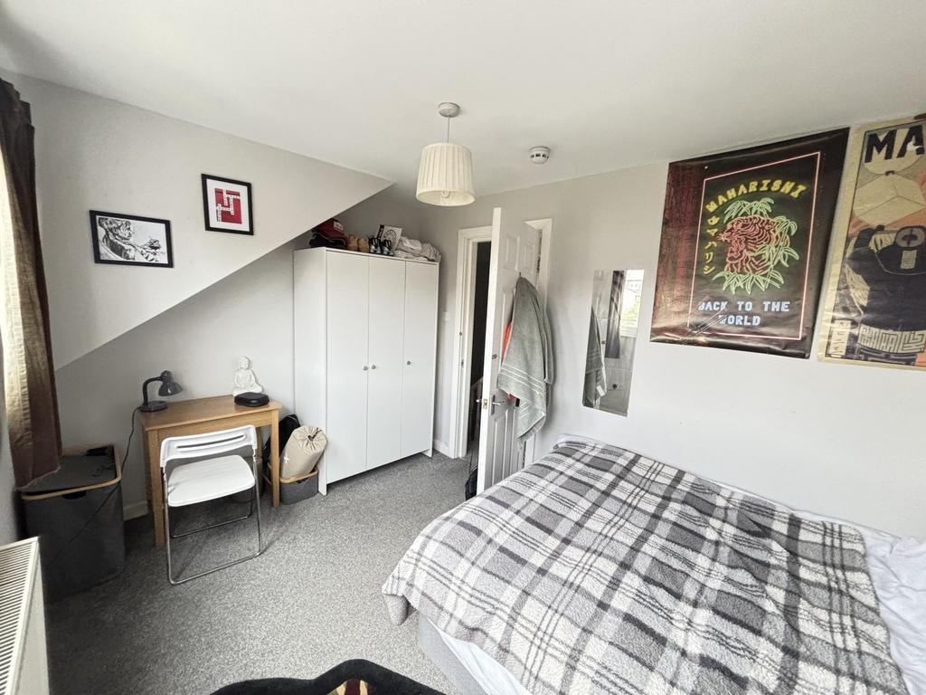 A tidy and well-lit bedroom featuring a comfort...