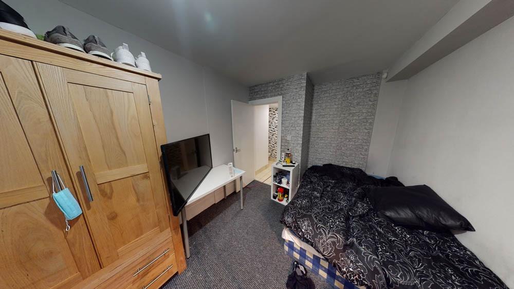 A cozy bedroom featuring a bed, wardrobe, and a...