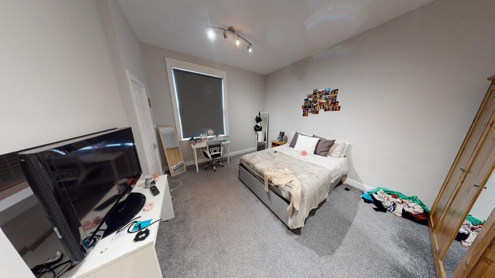 A well-lit, tidy bedroom featuring a double bed...