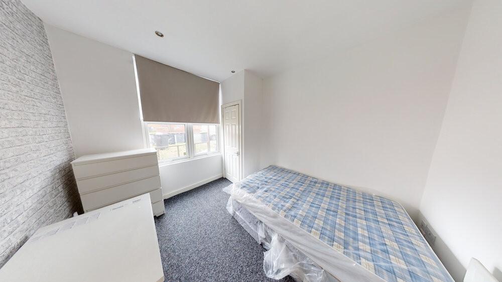 A tidy single bedroom with a comfortable bed, b...