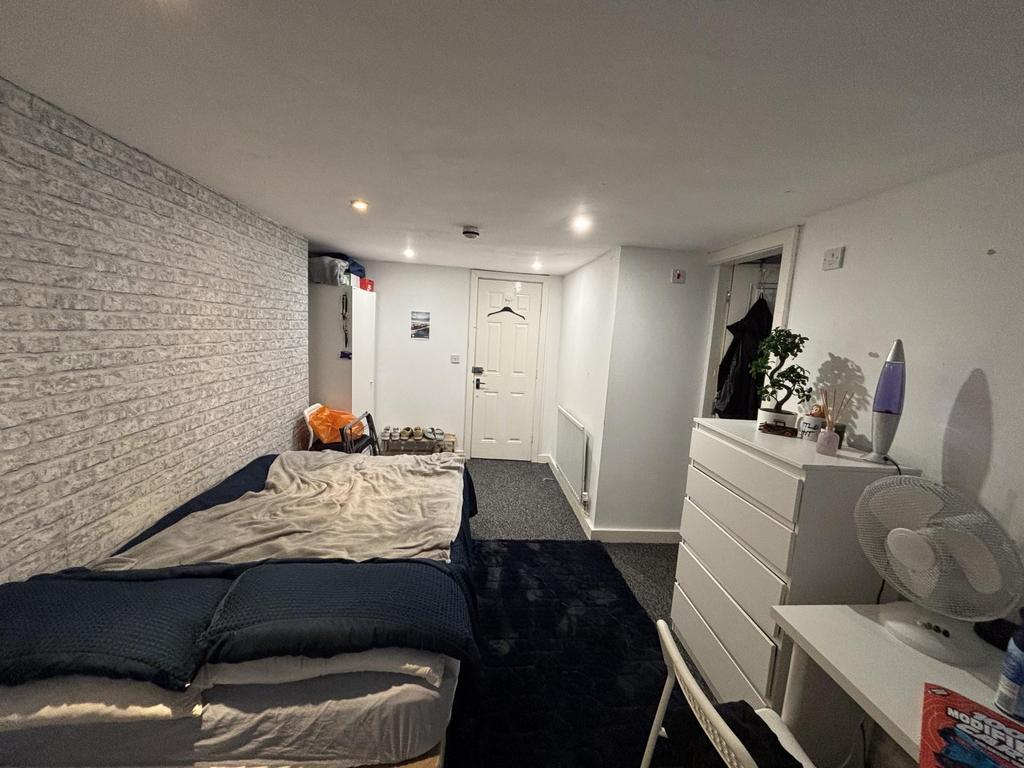 A well-lit bedroom featuring a comfortable doub...