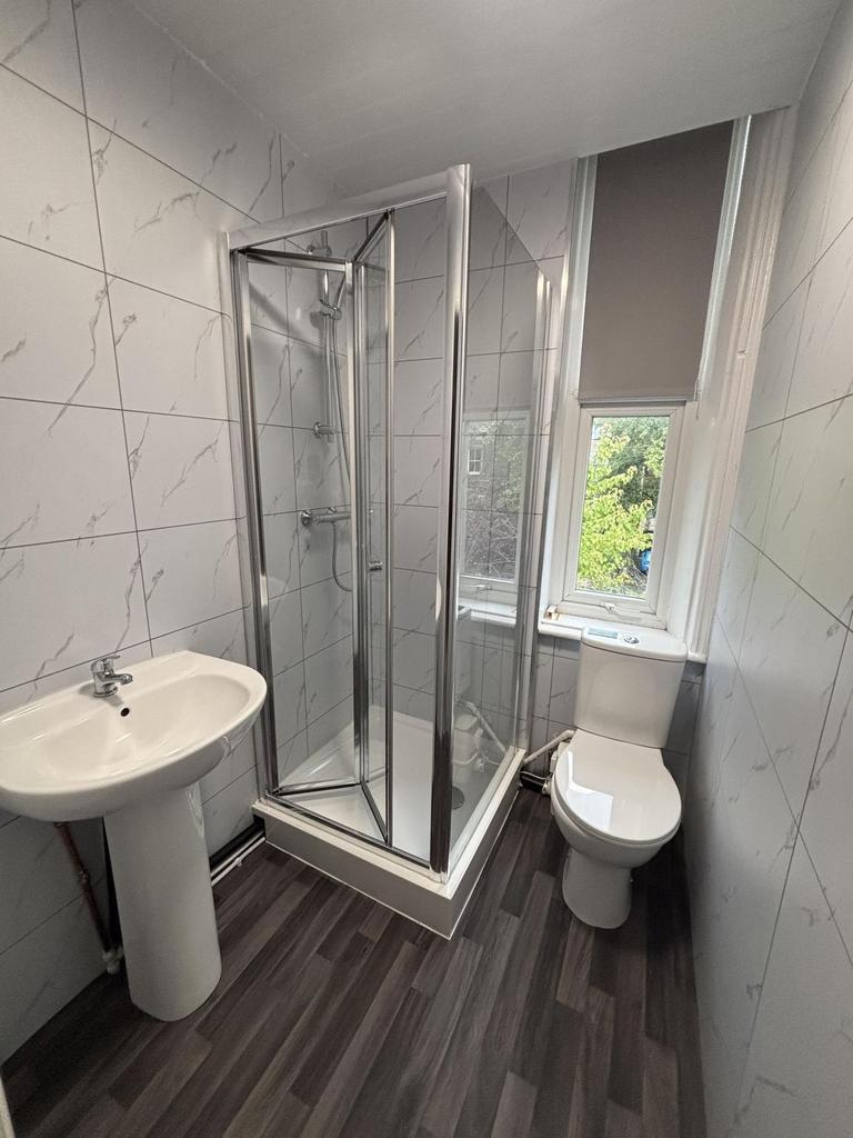 A well-maintained bathroom with a glass-enclose...