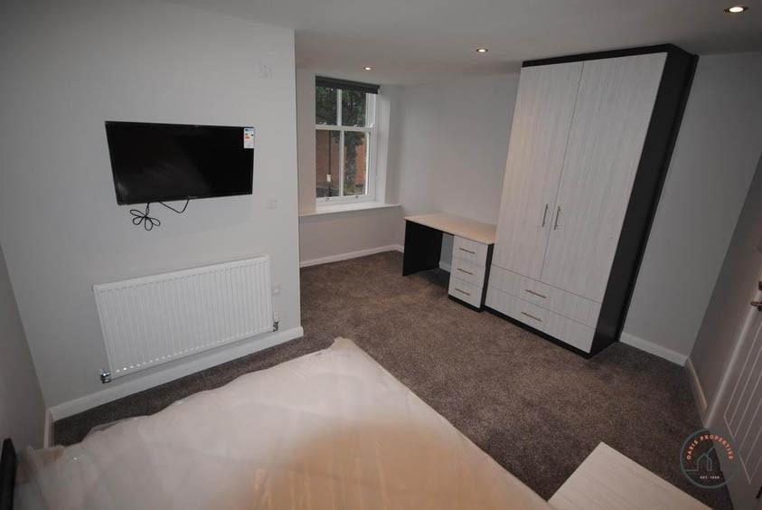 A well-maintained bedroom with clean, neutral d...