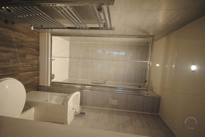 A well-lit, modern bathroom featuring a toilet ...