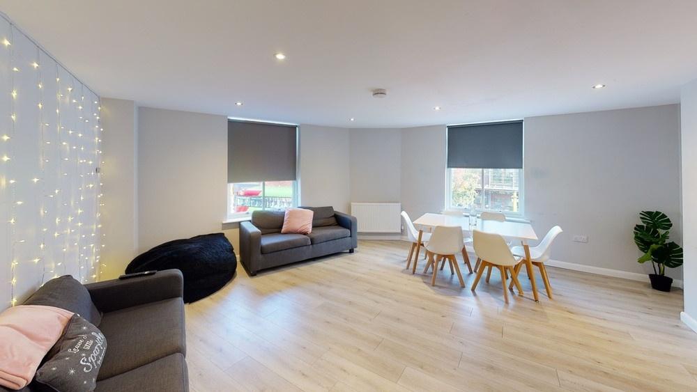A spacious, modern living room filled with natu...