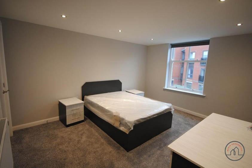 A spacious, modern bedroom featuring a double b...
