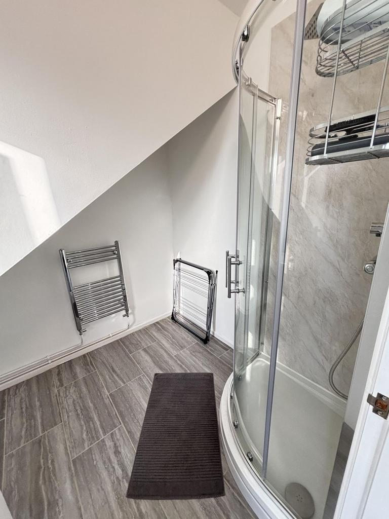 A modern bathroom featuring a curved glass show...
