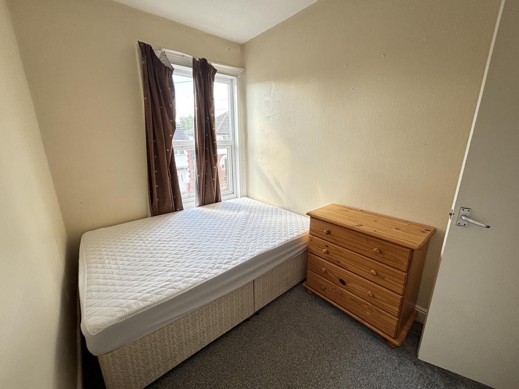 A small, tidy room featuring a single toilet wi...