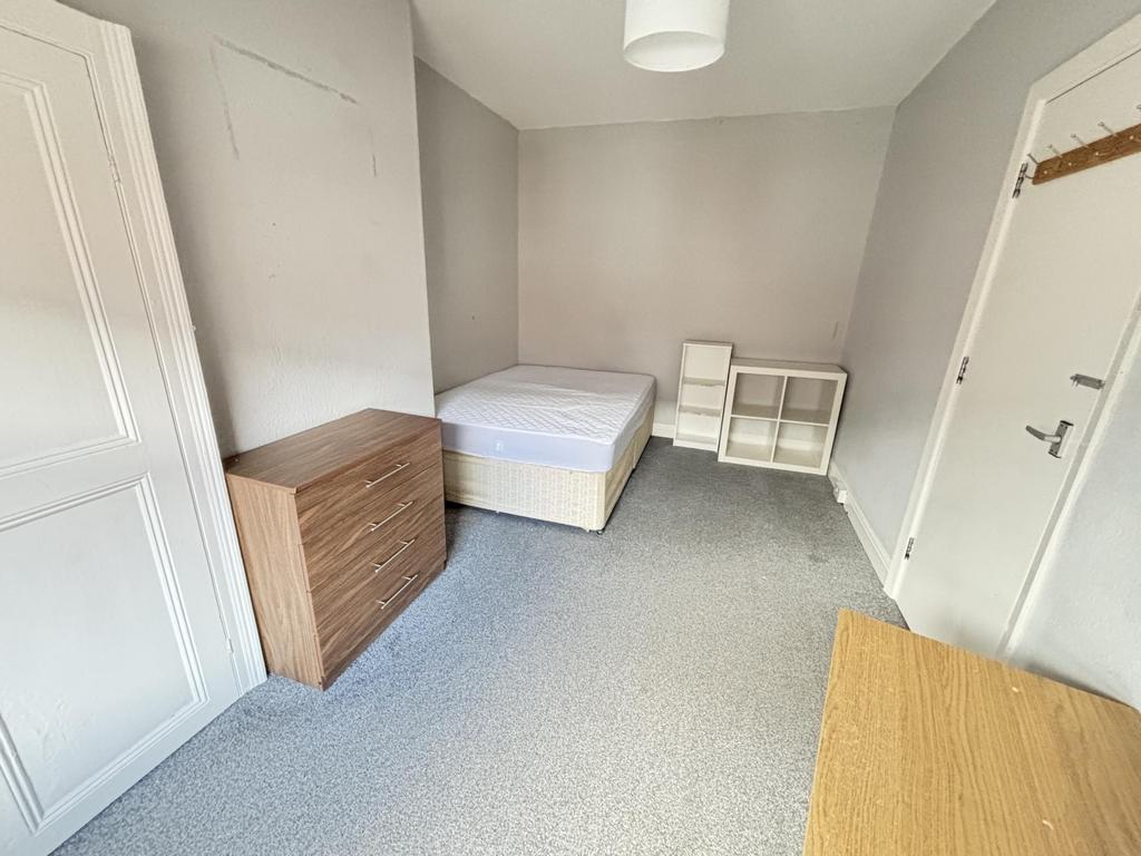 A simple, tidy bedroom with a single bed, a bed...