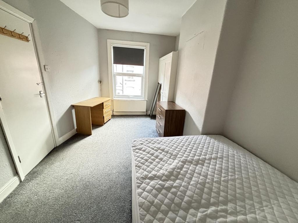 A bright and tidy single bedroom with a comfort...