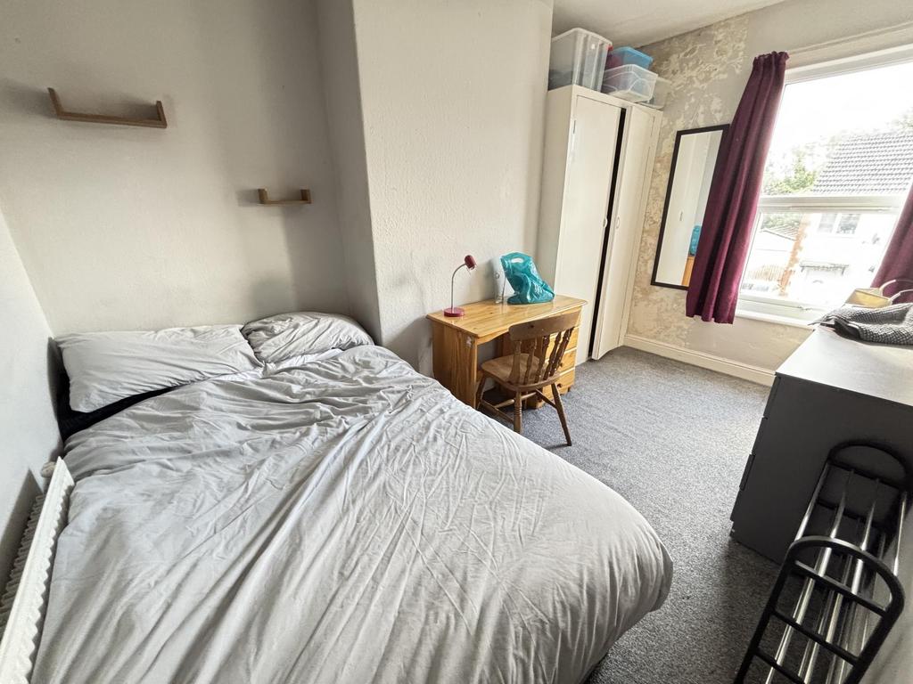 A cozy bedroom featuring a neatly made bed with...
