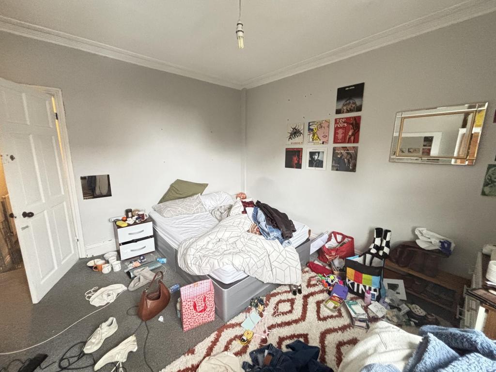 A casual living room with a sofa, cluttered sur...