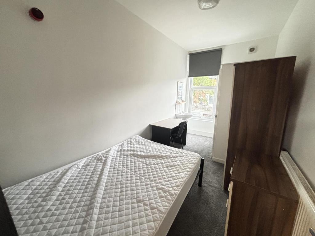 A neatly maintained bedroom featuring a double ...