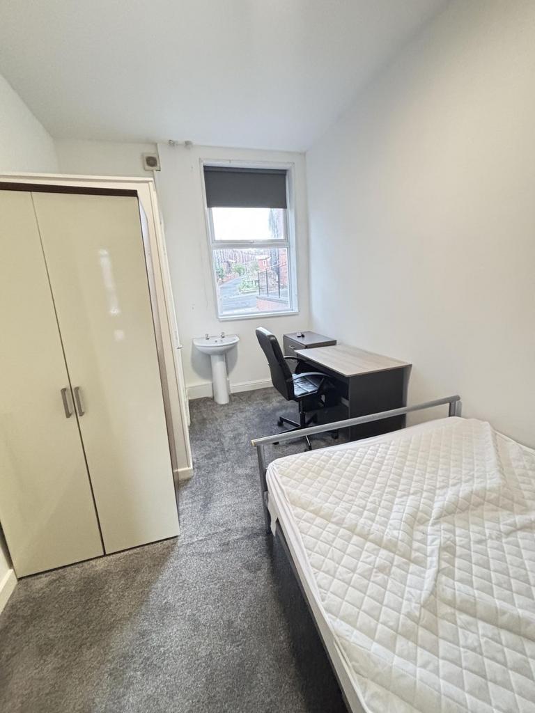 A tidy and bright small bedroom featuring a sin...