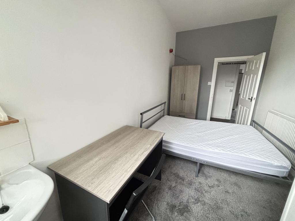A cozy bedroom featuring a double bed, a wardro...