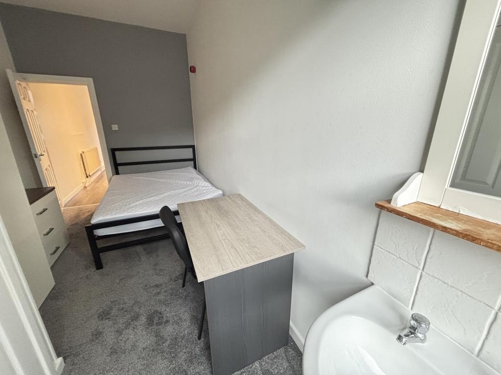 This image displays a small bathroom area featu...
