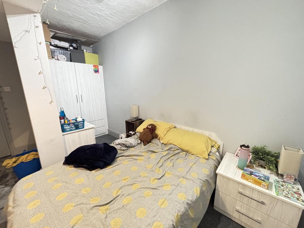 A cozy bedroom featuring a double bed dressed w...