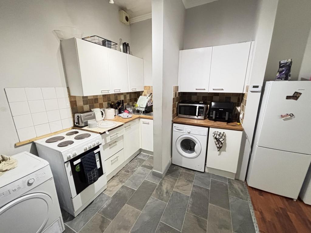 A tidy and well-lit kitchen with modern applian...