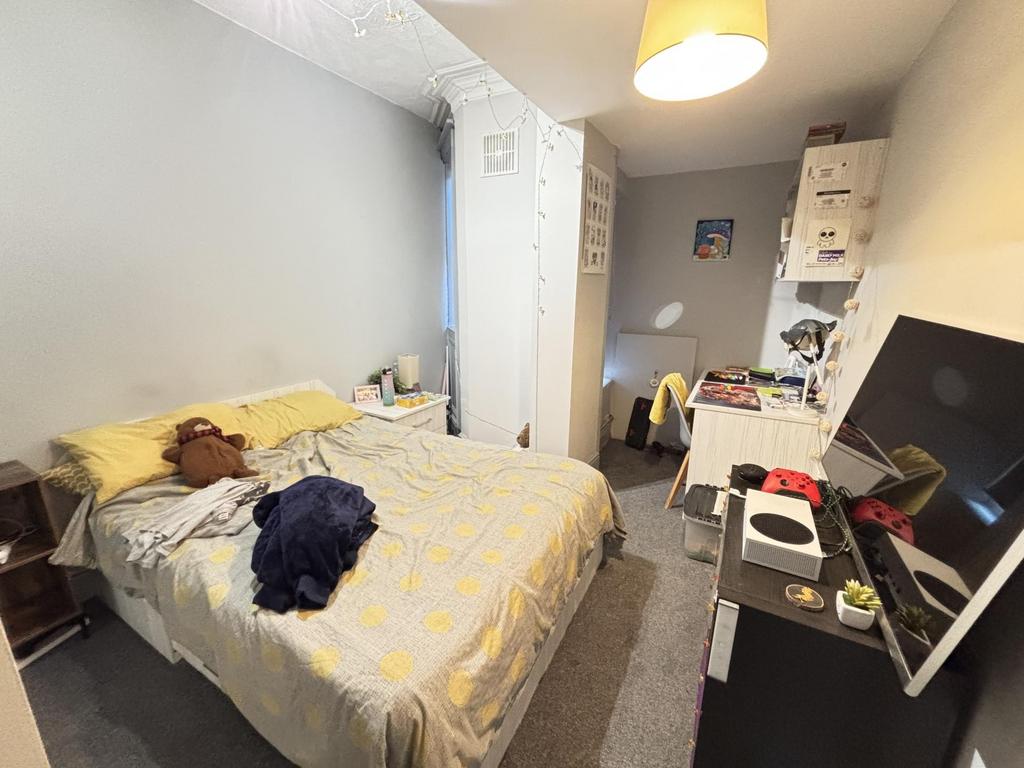 A cozy bedroom featuring a double bed and a com...