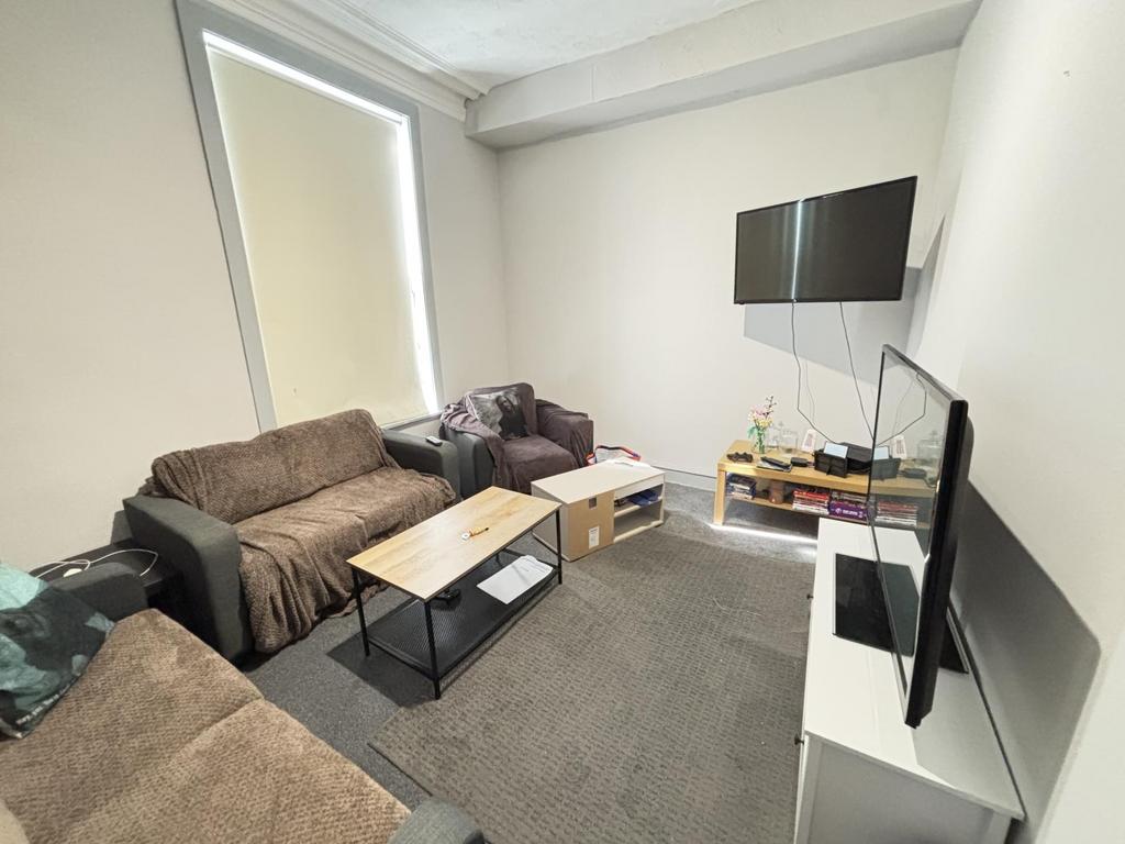A spacious, well-lit modern living room featuri...