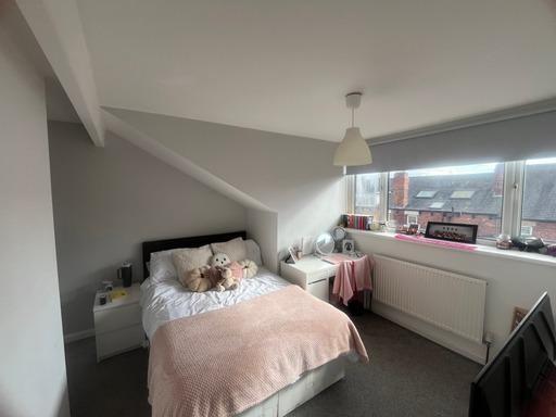 Bright and cozy master bedroom featuring a comf...