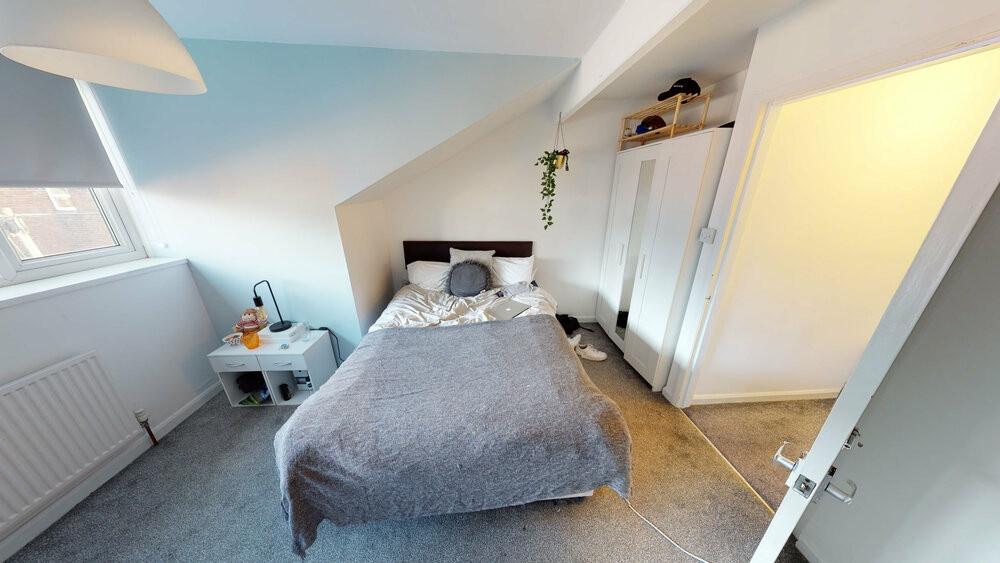 A spacious and well-lit master bedroom featurin...