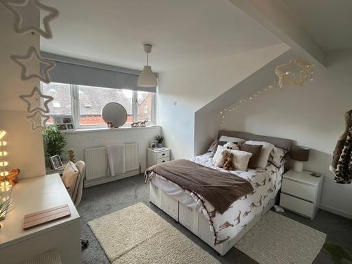 A spacious and well-lit master bedroom with a c...