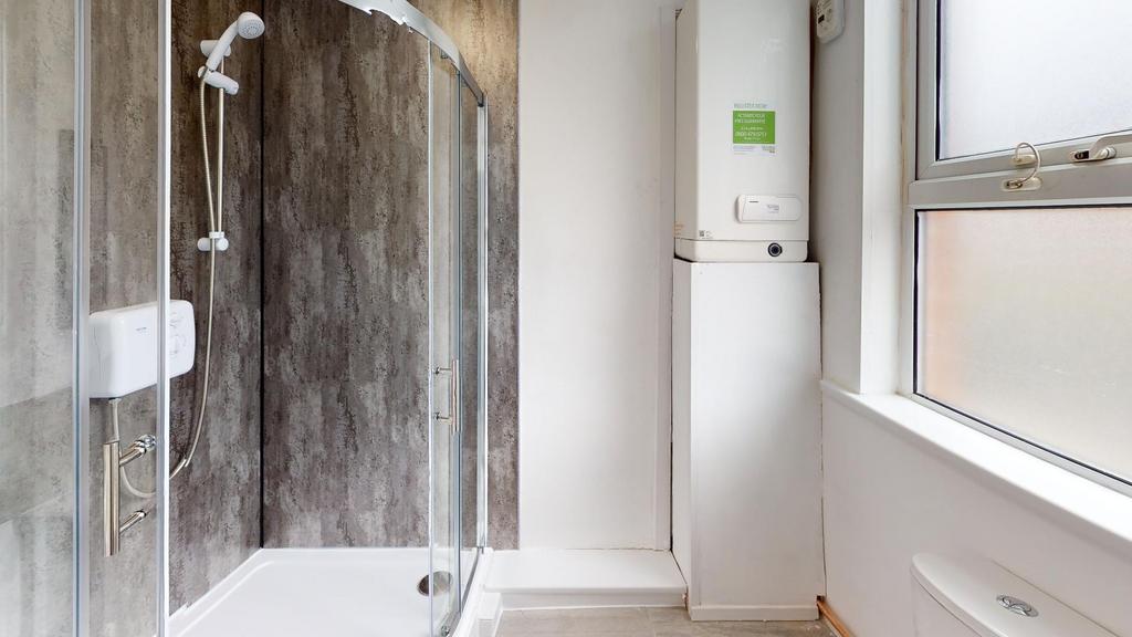 A clean and modern bathroom with a spacious sho...