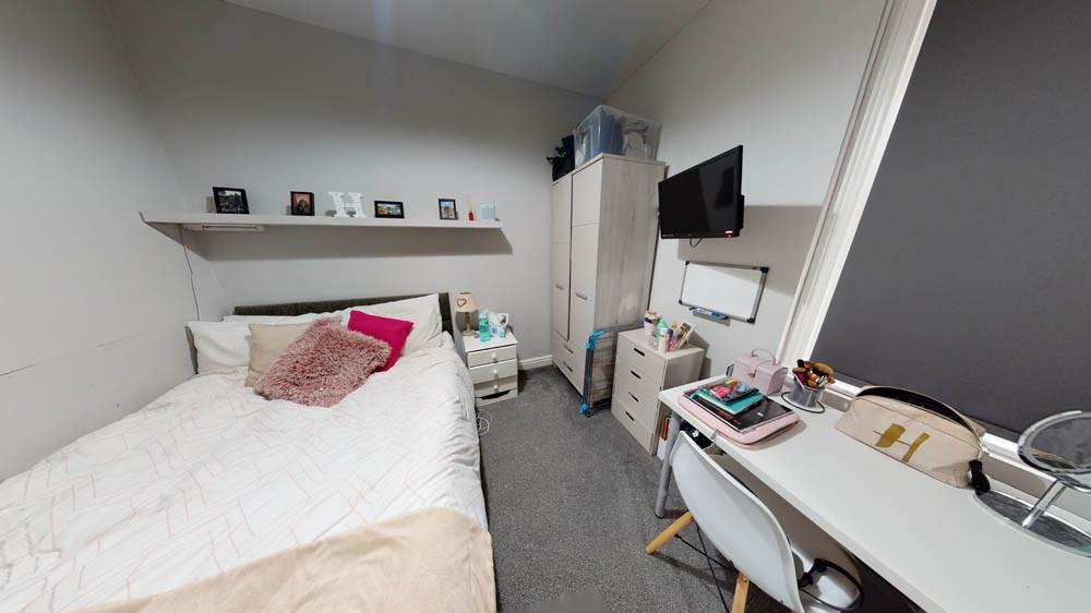 A cozy single bedroom featuring a comfortable b...