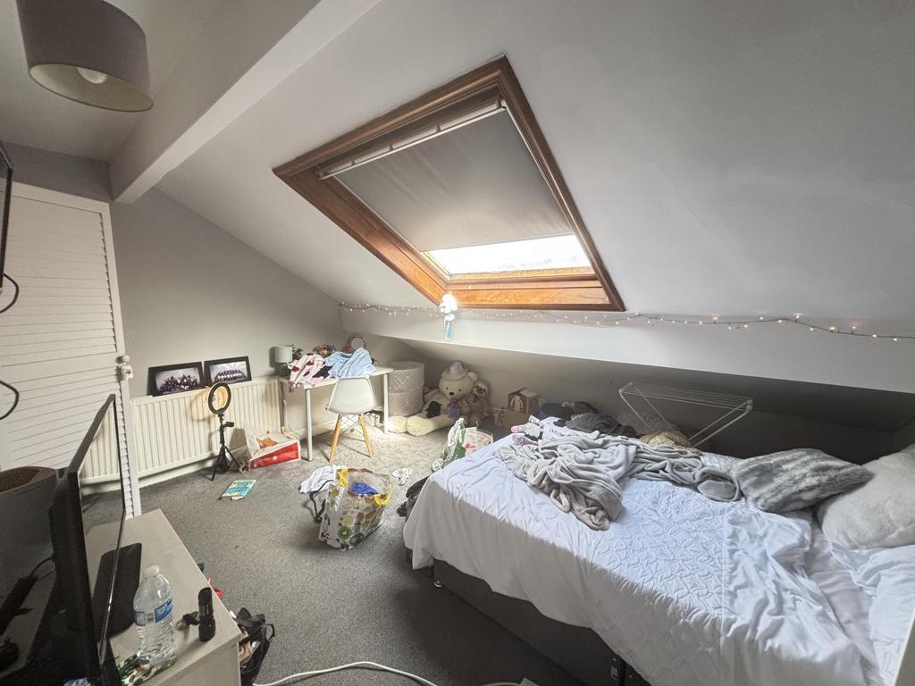 A cozy bedroom with a neatly made bed situated ...