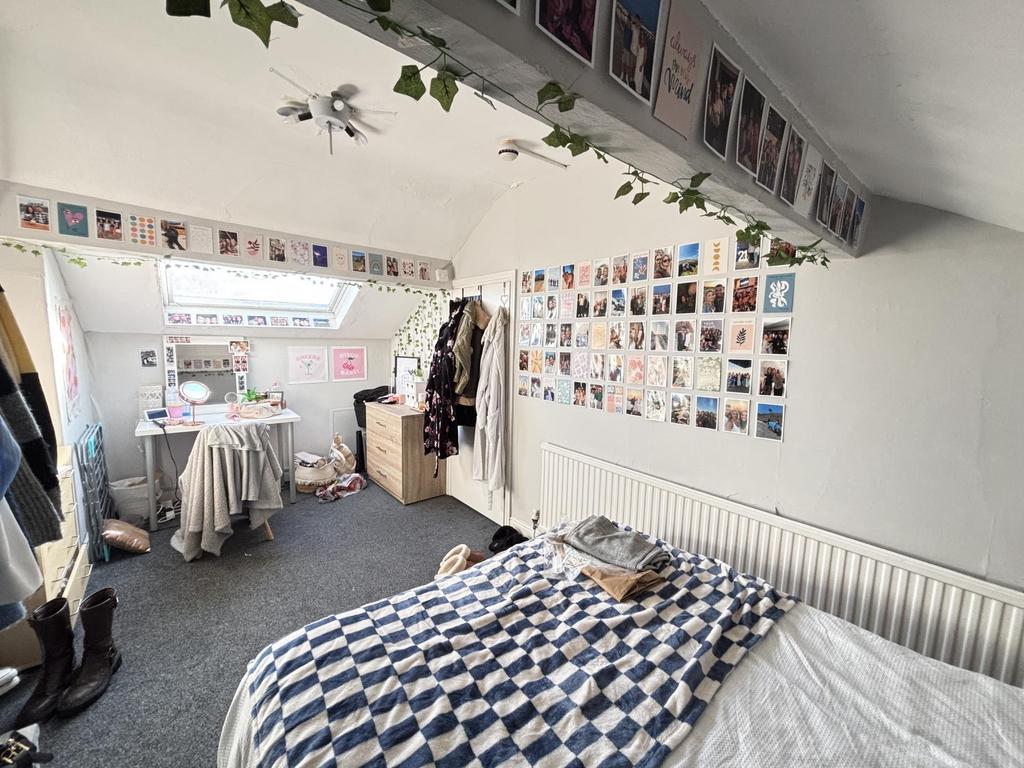 A bright and tidy student bedroom with a comfor...