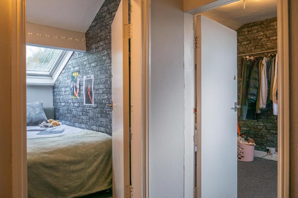 A well-lit master bedroom featuring a comfortab...