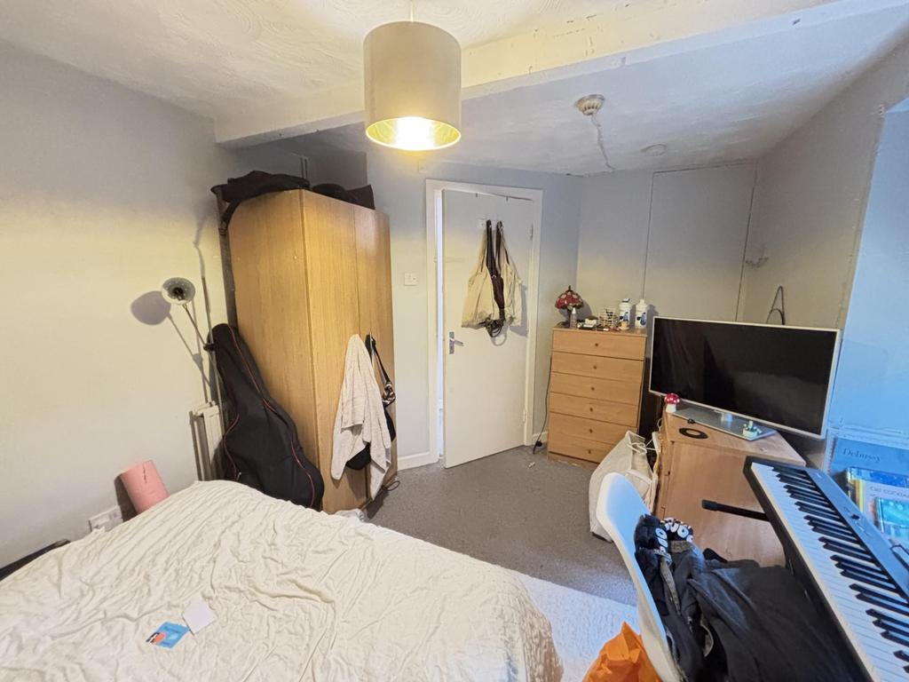 A cozy bedroom featuring a double bed, a wardro...