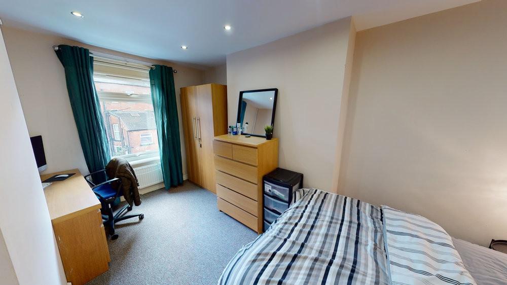 A tidy and well-lit bedroom featuring a comfort...