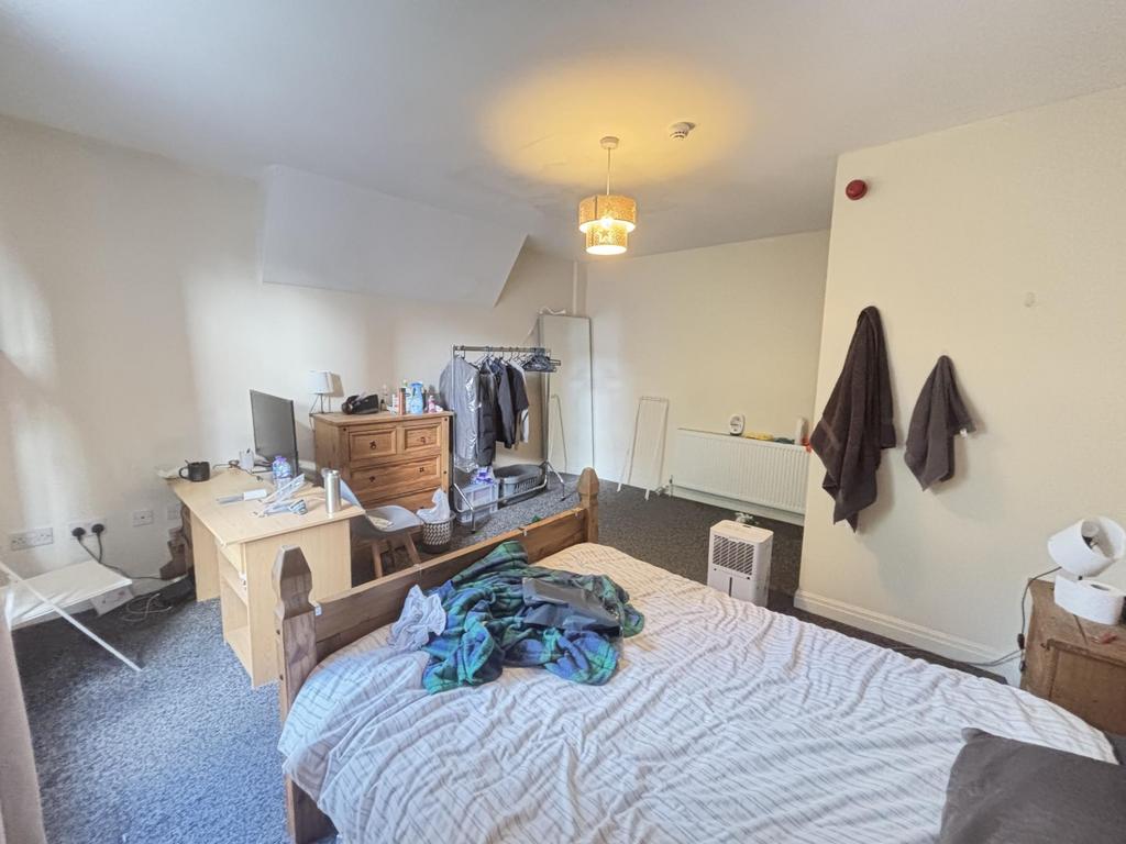 A cozy bedroom featuring a neatly made bed with...