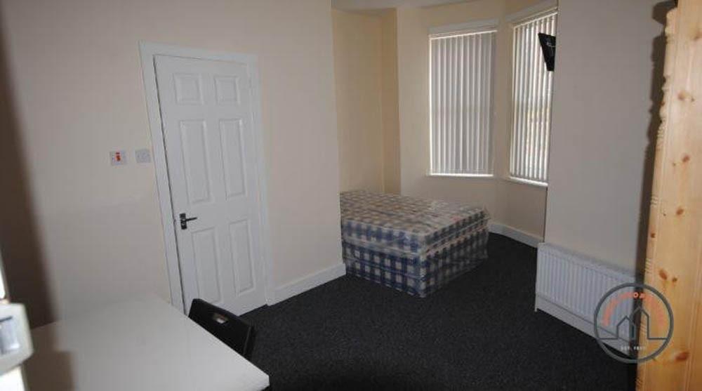 A well-lit double bedroom featuring a bed and a...