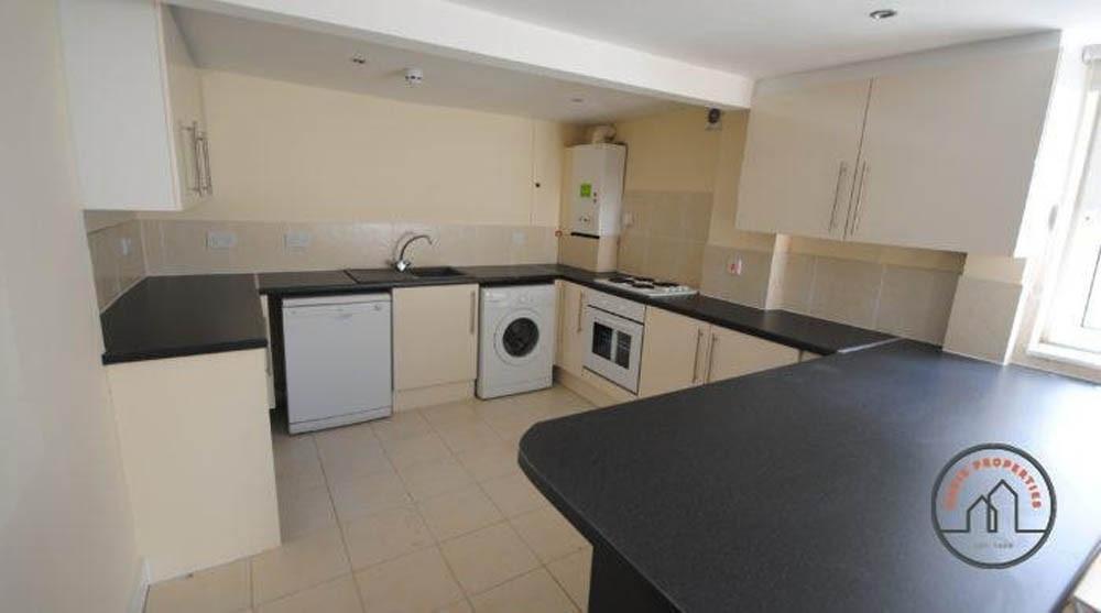 Modern fitted kitchen with light cabinetry, bla...