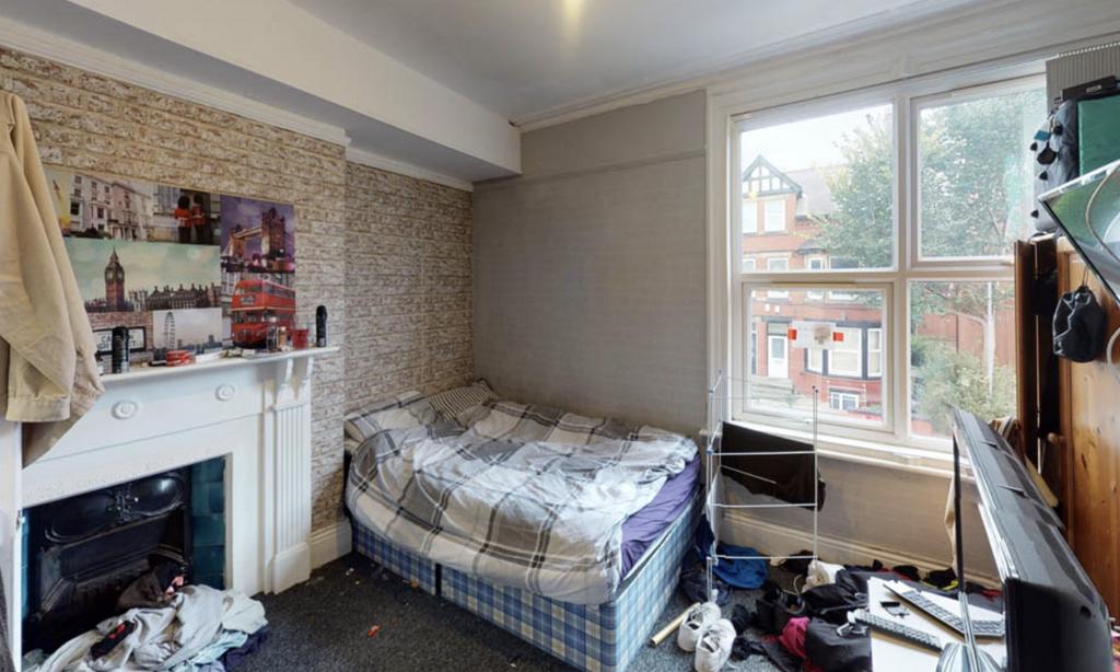 A cozy bedroom with a single bed placed near a ...