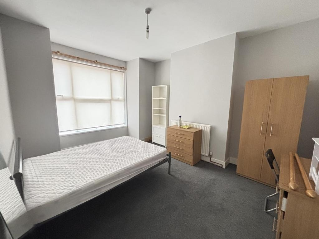A cozy student bedroom featuring a comfortable ...