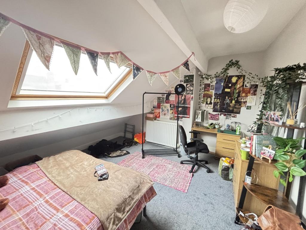 A cozy bedroom featuring a comfortable bed with...