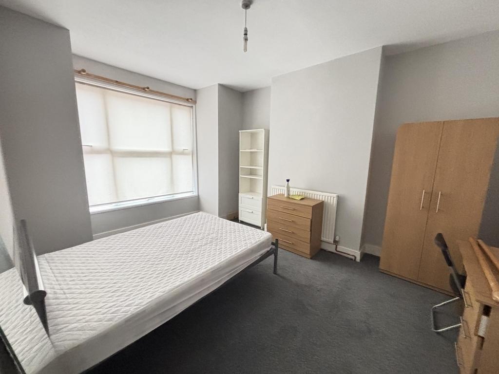 A tidy single bedroom featuring a single bed, a...