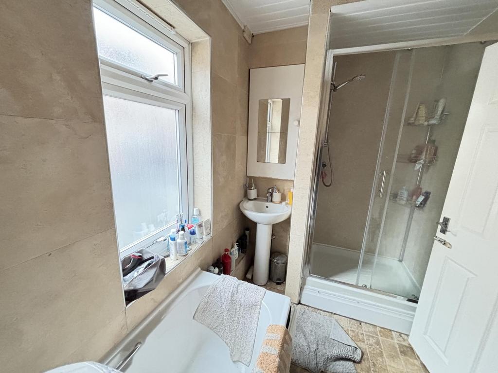 A clean, well-lit bathroom featuring a shower u...