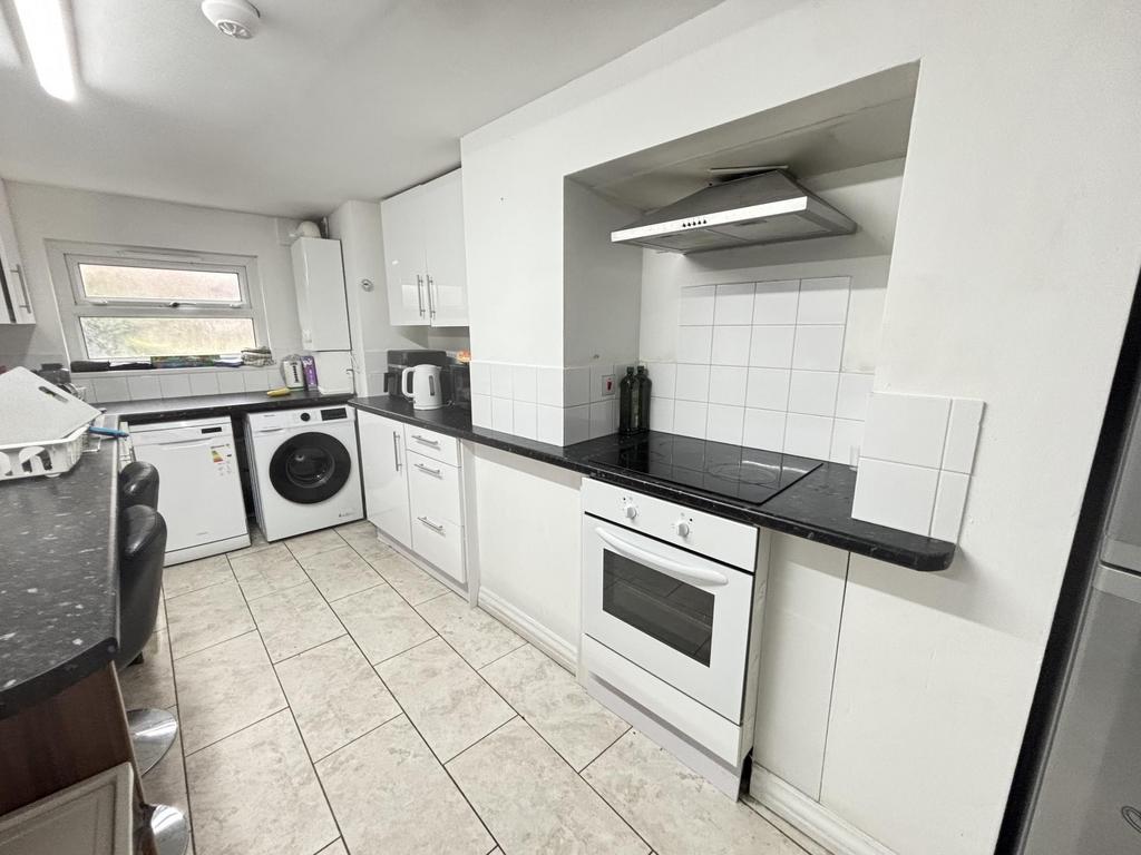 Bright galley-style kitchen with modern white c...
